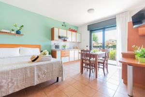 una camera con letto e una cucina con tavolo di Nettuno Residence Hotel a Peschiera del Garda