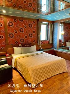 中壢區的住宿－賓士旅館，一间卧室配有一张带橙色墙壁的大床