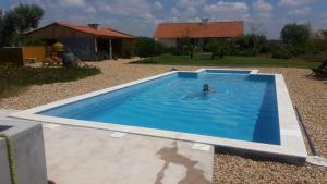 a person swimming in a swimming pool at o vale da mudança in Monte da Pedra Alva