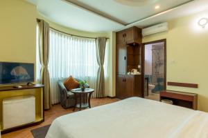 um quarto de hotel com uma cama e uma cadeira em Dahlia Boutique Hotel em Pokhara