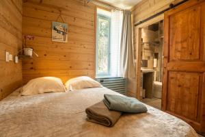 een slaapkamer met een bed in een houten kamer bij Arcanson in Méaudre +43 foto's