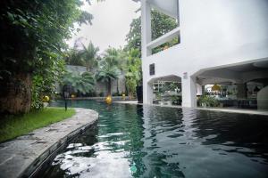 a swimming pool in front of a house at Arthur & Paul (Men Only Hotel) in Phnom Penh