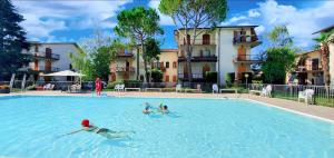 - un groupe de personnes se baignant dans une piscine dans l'établissement SoleGardaRelax - Peschiera del Garda, à Peschiera del Garda
