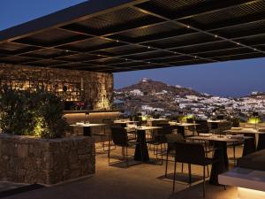 a restaurant with tables and chairs with a view at Noima Boutique Hotel Mykonos in Agios Ioannis Mykonos