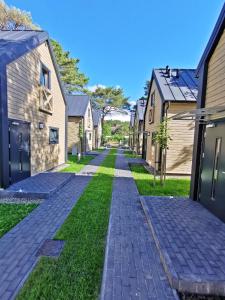 a cobblestone street in a residential neighborhood with houses at Ośrodek Wypoczynkowy Merkury in Mrzeżyno