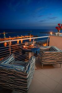 balcón con mesa, sillas y vistas al océano en Hibrido Boutique Hotel & Spa, en Sciacca