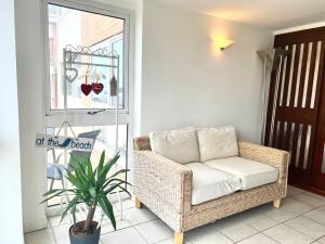 a rattan chair and a plant in a room at Beach Front Apartment with Free Parking, St Annes in Lytham St Annes