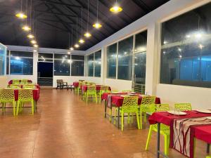 a room with tables and chairs with red and green tables at Firefly Resort in Kanthalloor