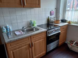 a kitchen with a sink and a stove at Lütt Verbliev in Malchow