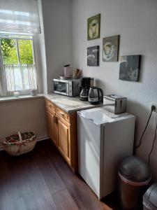 a small kitchen with a microwave and a dishwasher at Lütt Verbliev in Malchow