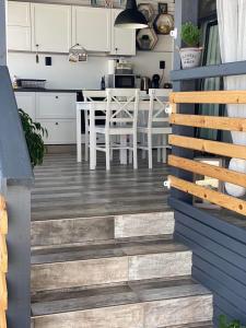 uma cozinha e sala de jantar com armários brancos e piso de madeira em La Veranda Sinemorets em Sinemorets
