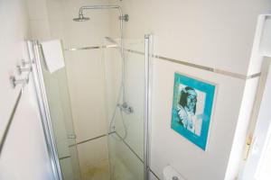 baño con ducha y una pintura en la pared en Livingtarifa Apartamento Bianco, en Tarifa