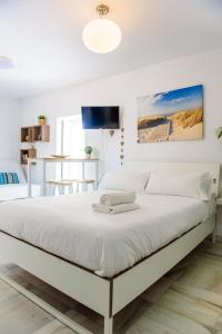 Un dormitorio blanco con una gran cama blanca. en Livingtarifa Apartamento Bianco, en Tarifa