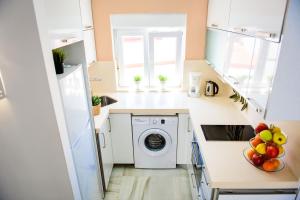 una pequeña cocina con lavadora y secadora. en Livingtarifa Apartamento Bianco, en Tarifa