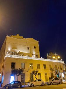 dos autos estacionados frente a un edificio por la noche en Castello Castriota Scanderbeg, en Galatina