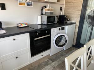 a kitchen with a washing machine and a microwave at La Veranda Sinemorets in Sinemorets