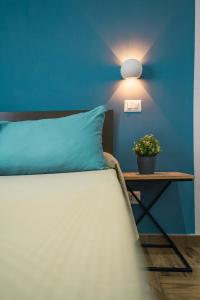 une chambre bleue avec un lit et une table avec une plante dans l'établissement Spaghetti House, à Naples