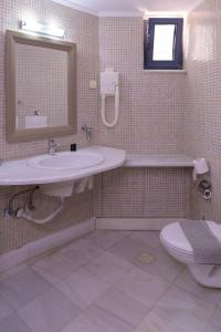 a bathroom with a sink and a toilet and a mirror at Elizabeth Suites in Kato Daratso