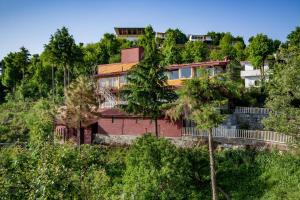 卡纳塔尔Avalon Cottages, Kanatal by Leisure Hotels的山边树木的房子