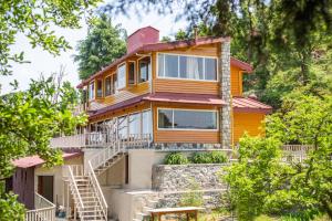 卡纳塔尔Avalon Cottages, Kanatal by Leisure Hotels的黄色的房子,楼梯上方