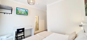 a white bedroom with a bed and a desk at ESPERANCE HOTEL in Nice