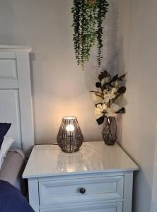 a white table with two vases of flowers on it at Kadi House - Unit 1 in Wynyard