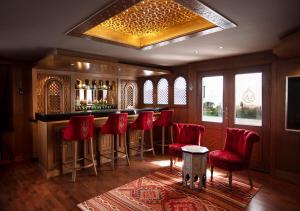 um bar com bancos de bar vermelhos num quarto em Dahabeya Yakouta Nile Cruise-Every Monday from Luxor- Aswan for 05 nights em Luxor