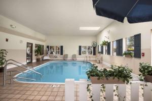 a large swimming pool in a house with an umbrella at Days Inn by Wyndham Oglesby/ Starved Rock in Oglesby