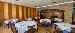 a dining room with tables and chairs with white tablecloths at Casa Emilio in Torre Baja