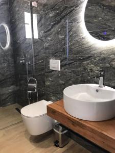 a bathroom with a white sink and a toilet at Hotel Villa Ruci in Ksamil