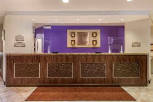 a bar in a lobby with a purple wall at Comfort Suites Maingate East in Orlando