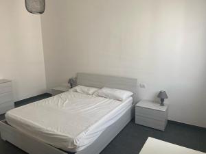 ein Schlafzimmer mit einem weißen Bett und zwei Nachttischen in der Unterkunft Casa Stella in Scandicci