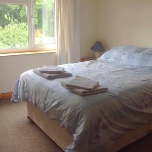 a bedroom with a bed with towels on it at 3 bedroom Grade II Listed Holiday Cottage in Saint Erth