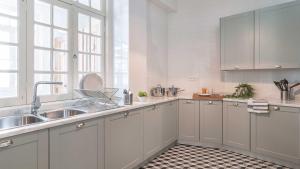a kitchen with white cabinets and a sink at RUN Aveiro in Aveiro