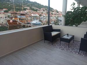 uma varanda com cadeiras e vista para um porto em Apartman Vranac em Vela Luka