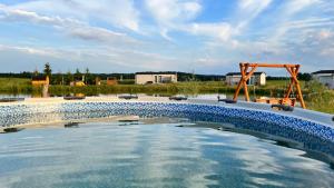 uma piscina de água com um baloiço num campo em Domki przy Ośrodku Narciarskim Trzepowo em Trzepowo