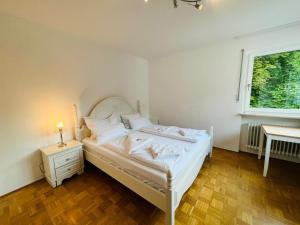 珀科英的住宿－Ferienwohnungen Sisi，卧室配有白色的床和窗户。