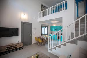 a living room with a staircase and a dining room at Amarynthos Maisonettes in Amarynthos