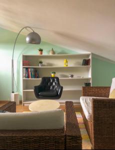 a living room with a black chair and a table at Offshore Rustic House in Peniche