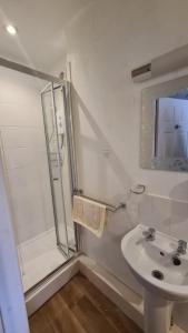 a white bathroom with a shower and a sink at The Foresters Arms in Tarporley