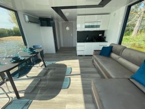 un soggiorno con un divano e un tavolo di Boathousing - apartament na wodzie, dom pływający, łódź, luksusowy apartament a Myślibórz