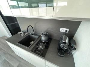 un bancone della cucina con lavandino e bollitore per il tè di Boathousing - apartament na wodzie, dom pływający, łódź, luksusowy apartament a Myślibórz