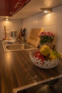 a kitchen counter with a bowl of fruit and a sink at Anna 1 by SMR Rauris Apartments - inc Spa and National Summercard - near Gondola in Rauris