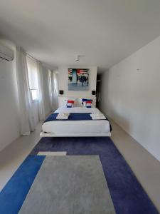 duża sypialnia z dużym łóżkiem z niebieskim dywanem w obiekcie Croissant de Lune w mieście Bagard