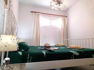 a bedroom with a green bed with a chandelier at Mareverde Elisa, 1 bedroom & Wifi Free in Adeje +12 photos