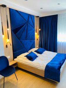 a bedroom with a large bed with a blue headboard at Diament i Brylant in Rawicz
