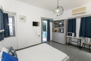 Pokój z łóżkiem i stołem z kuchenką mikrofalową w obiekcie Villa Ilios w mieście Parga