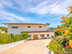 a house with a driveway and flowers at Villa AUREA Sea View in Koh Samui