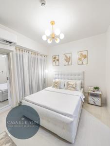 1 dormitorio blanco con 1 cama y ventilador de techo en White Nordic Fully-Furnished Studio at INSPIRIA en Davao