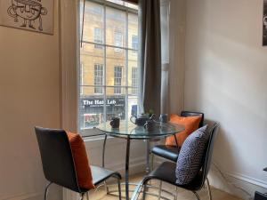 a table and chairs in a room with a window at Earl Grey flat by HNFC Stays - Finest tea & Coffee in Newcastle upon Tyne